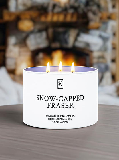 Tin Candle labeled 'Snow-Capped Fraser' burning in front of a fireplace.