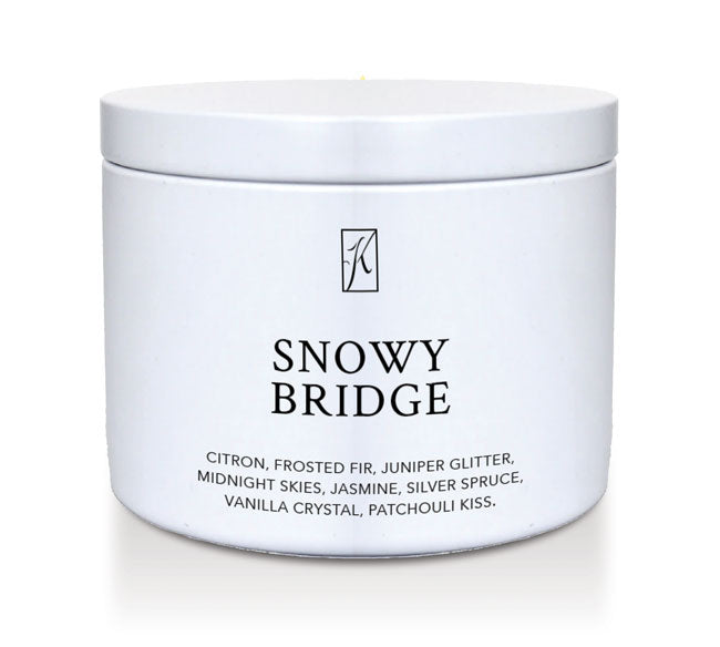 White candle tin labeled 'Snowy Bridge' with a brand logo on a white background
