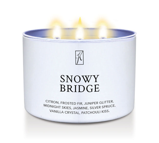 Candle in a white tin labeled 'Snowy Bridge' with flames on a white background