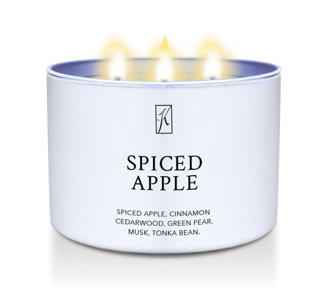 Candle in a white container labeled 'Spiced Apple' with flames on a white background
