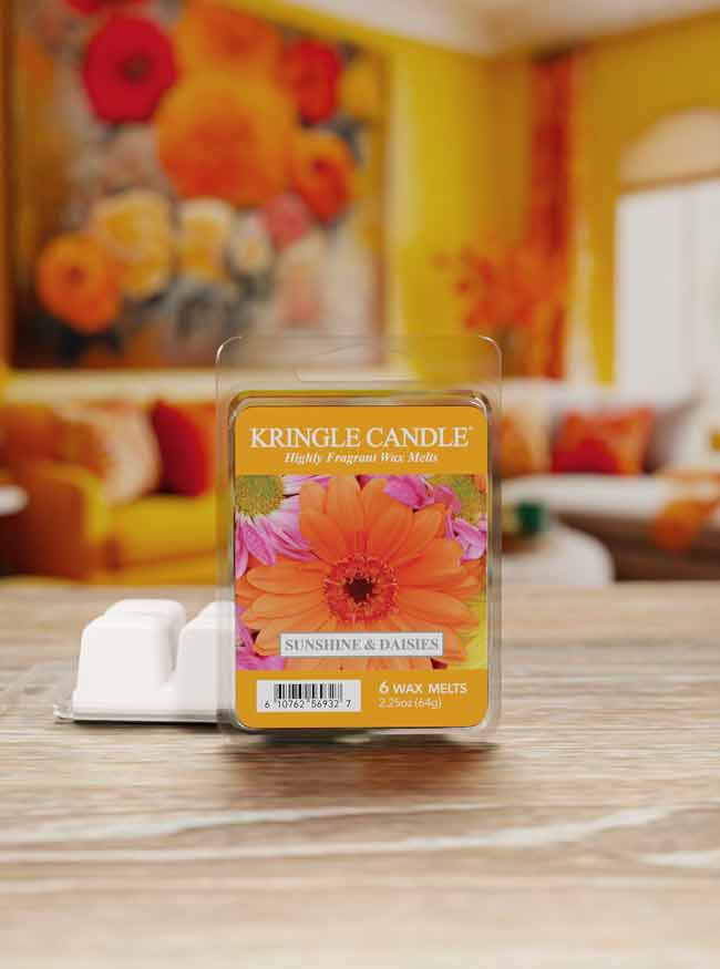 Kringle Candle wax melt package on a table with a floral painting in the background