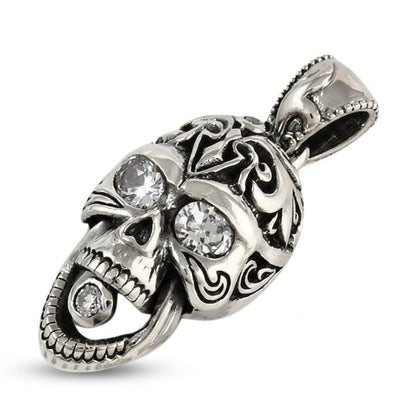 Angled view of the silver skull pendant displaying tribal cranium patterns and clear CZ stones in the eyes and open jaw.