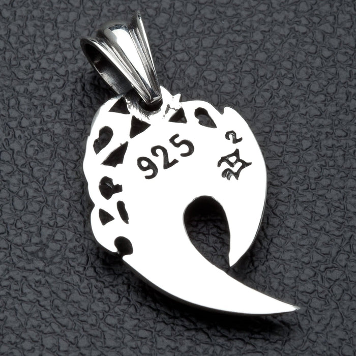 The back of the silver fang pendant, showing the .925 hallmark stamp and openwork design.