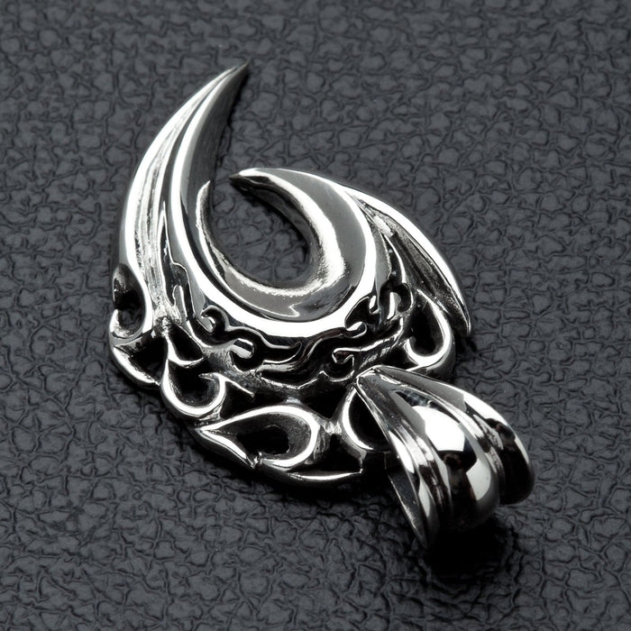 A close-up macro shot of the flame engravings inside the sterling silver fang pendant.