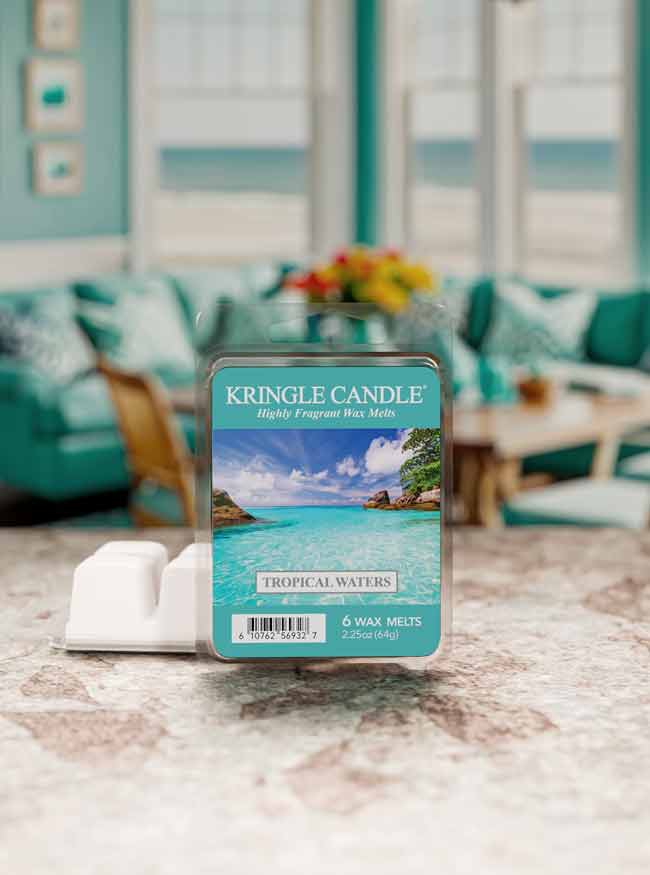 Kringle Candle Tropical Waters wax melt packaging on a marble surface with a blurred living room background.