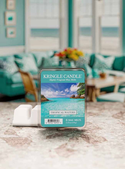 Kringle Candle Tropical Waters wax melt packaging on a marble surface with a blurred living room background.