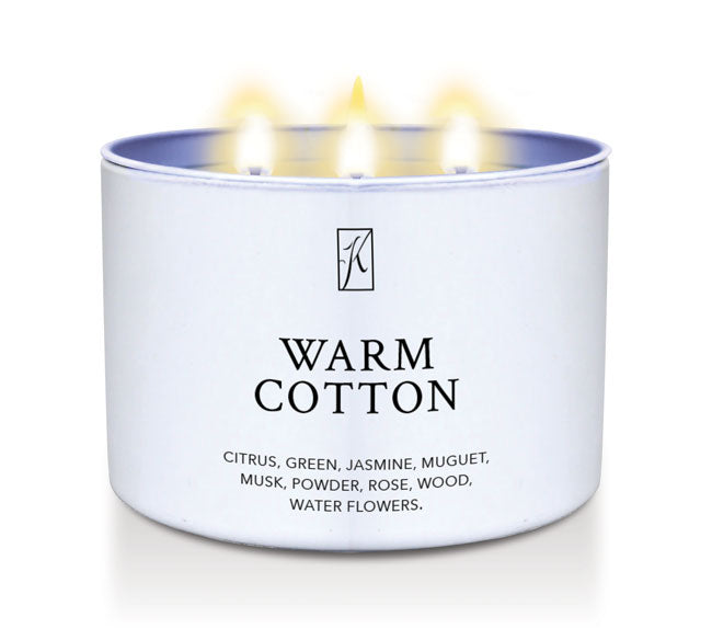 Candle in a white container labeled 'Warm Cotton' with a logo on a white background