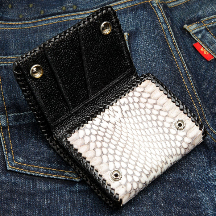 The handcrafted cobra wallet open on denim, showing the interior.