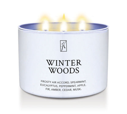Candle in a white container labeled 'Winter Woods' with flames on a white background