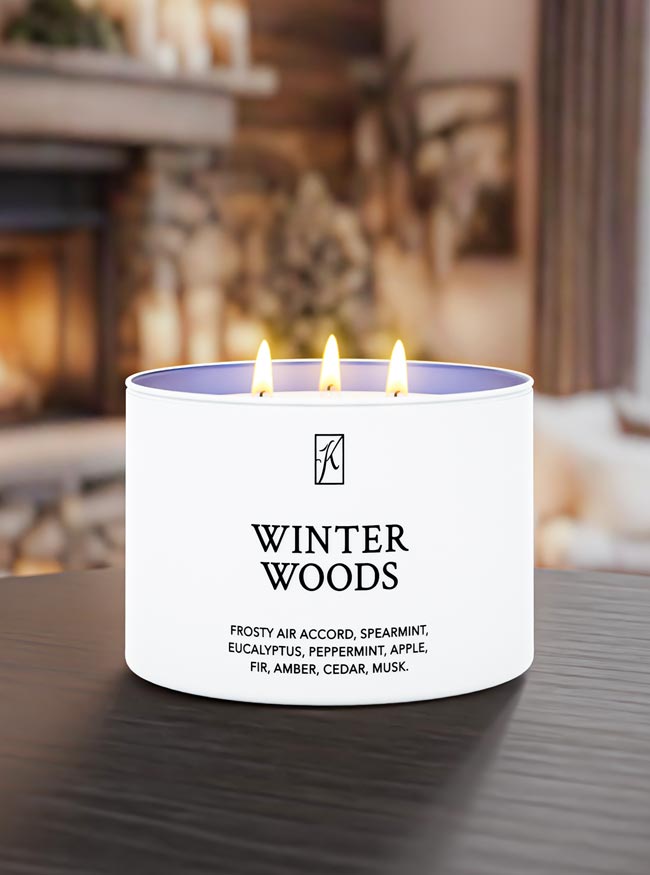 Candle labeled 'Winter Woods' on a table with a blurred background