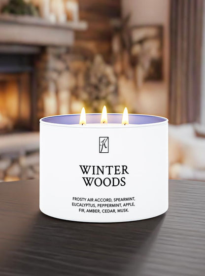 Candle labeled 'Winter Woods' on a table with a blurred background