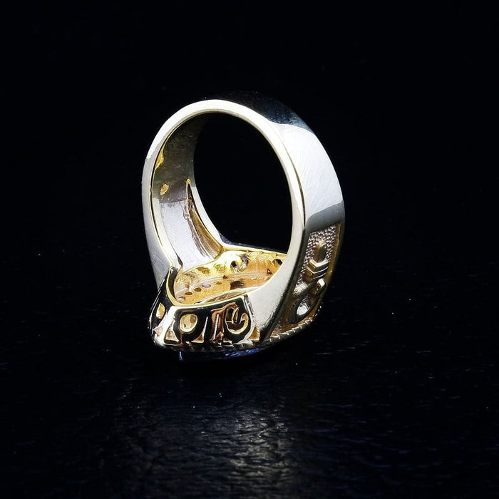 A detail shot of the bishop ring jewelry, revealing the intricate texture of the band and the embossed crosier symbol.