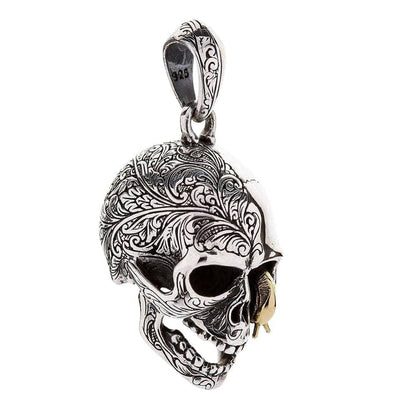 Angled shot of the worm skull pendant illustrating the duality between the engraved and polished halves.